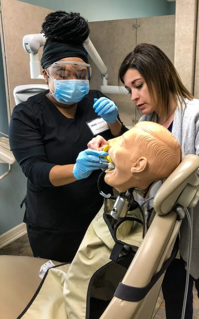 Instructor coaching a student on a patient simulator