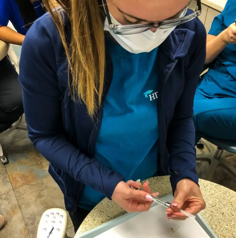 Student loading a dental instrument during lab practice