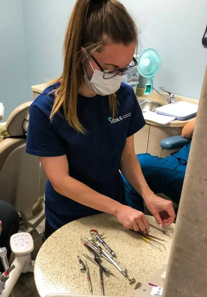 Student arranging instruments on the tray before a procedure