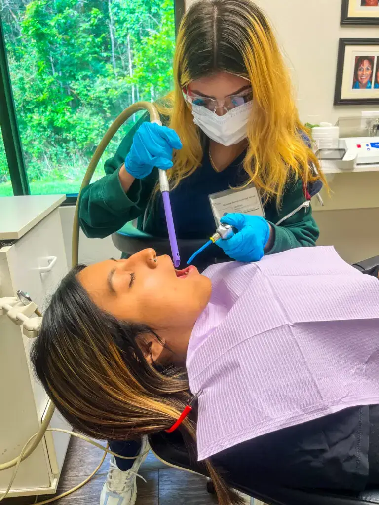 Student using the saliva ejector on a classmate during a Saturday lab